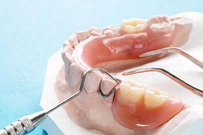 Closeup of dental tools next to partial dentures in Bedford