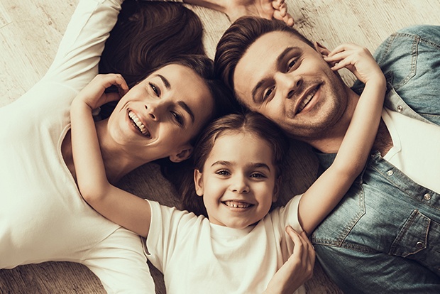 Family smiling together after visiting their dentist