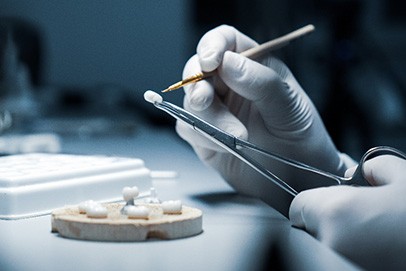 Lab tech working on customizing a dental crown