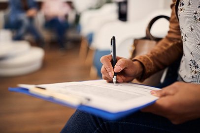 Woman filling out form on blue clipboard