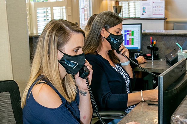 Two dental team members answering phones