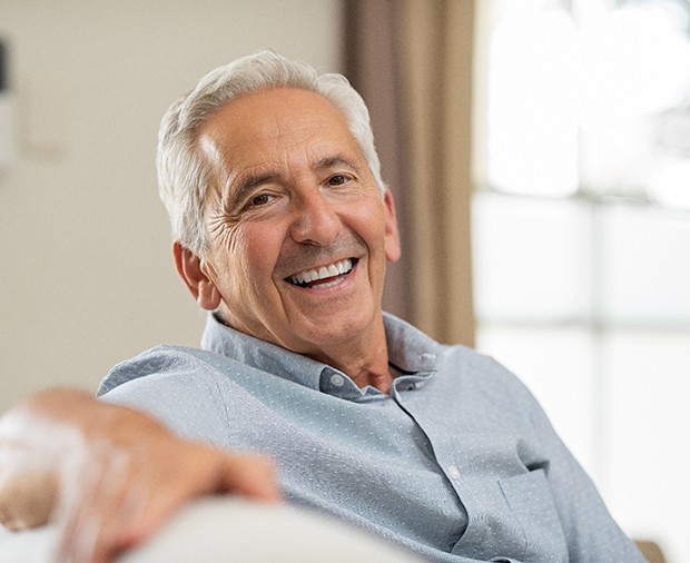 man smiling while sitting on couch 