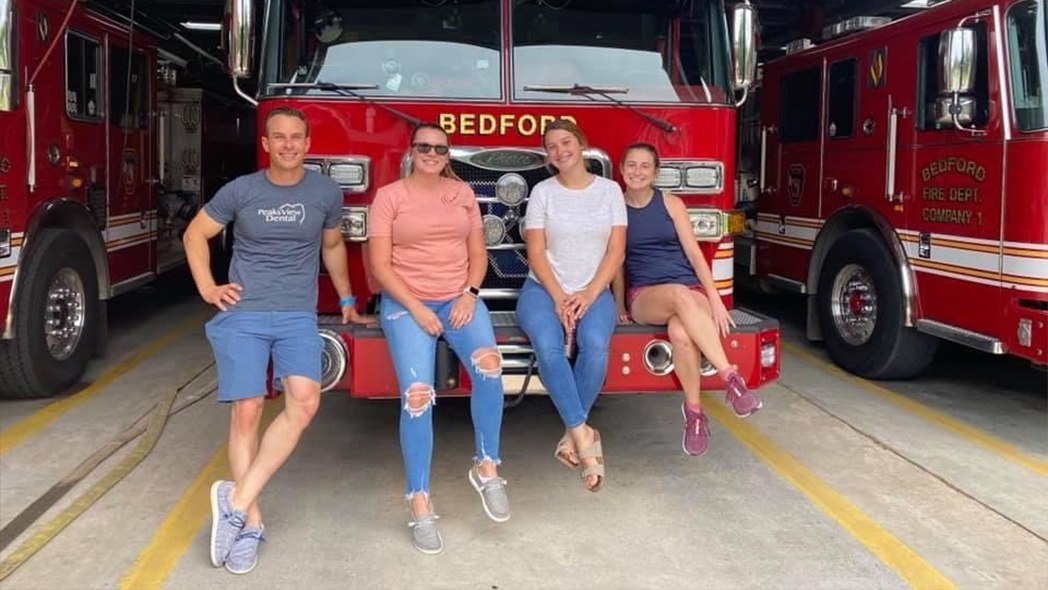 Dental team members posing in front of fire truck