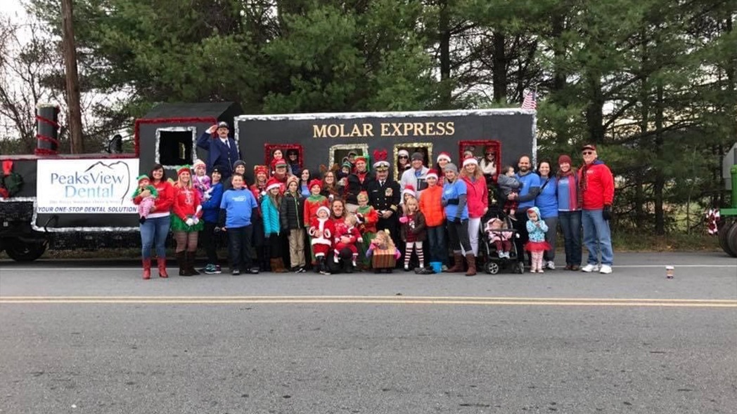 Dental office team in front of Molar Express vehicle