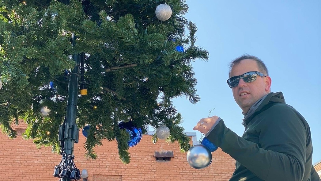 Dentist decorating large outdoor Christmas Tree
