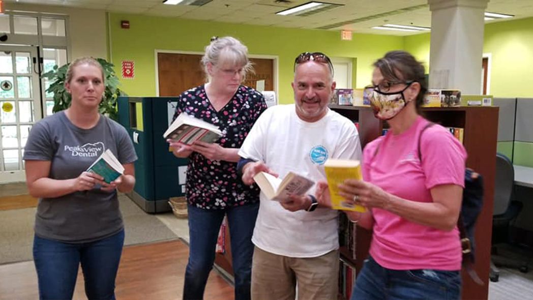 Dental team members reading books at the library