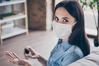 Dental patient using hand sanitizer in dental office waiting area