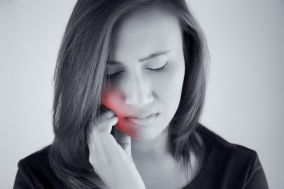 Woman with toothache holding cheek in pain