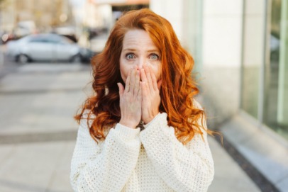 Woman with knocked out tooth covering her mouth