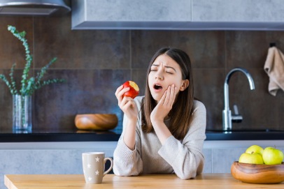 Woman with lost filling holding cheek