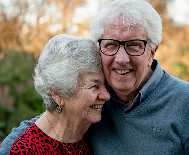 Man and woman smiling after dental implant tooth replacement