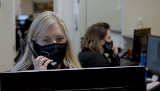 Dental team member wearing a face mask answering phone