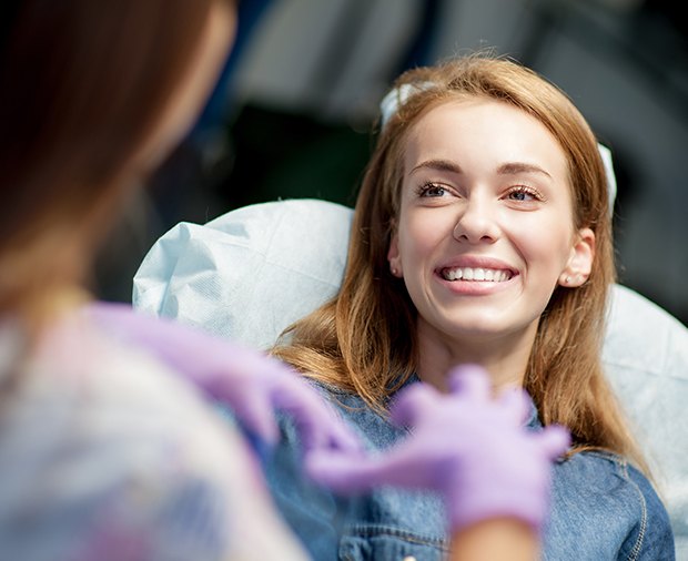 Woman smiling during dental checkup and teeth cleaning visit