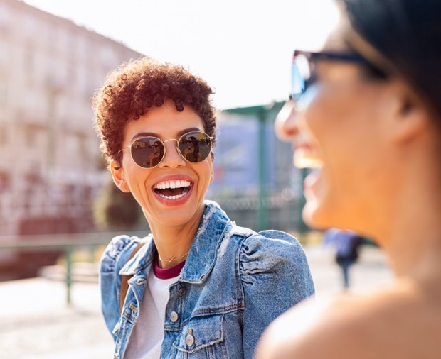 Two women smiling together after receiving dental services