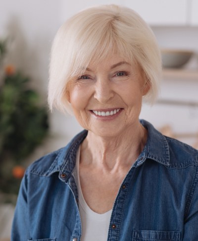 Older woman with healthy smile after replacing missing teeth