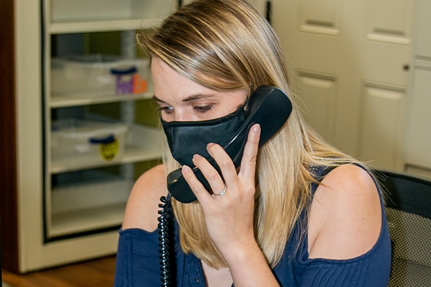 Dental team member with face mask answering the phone