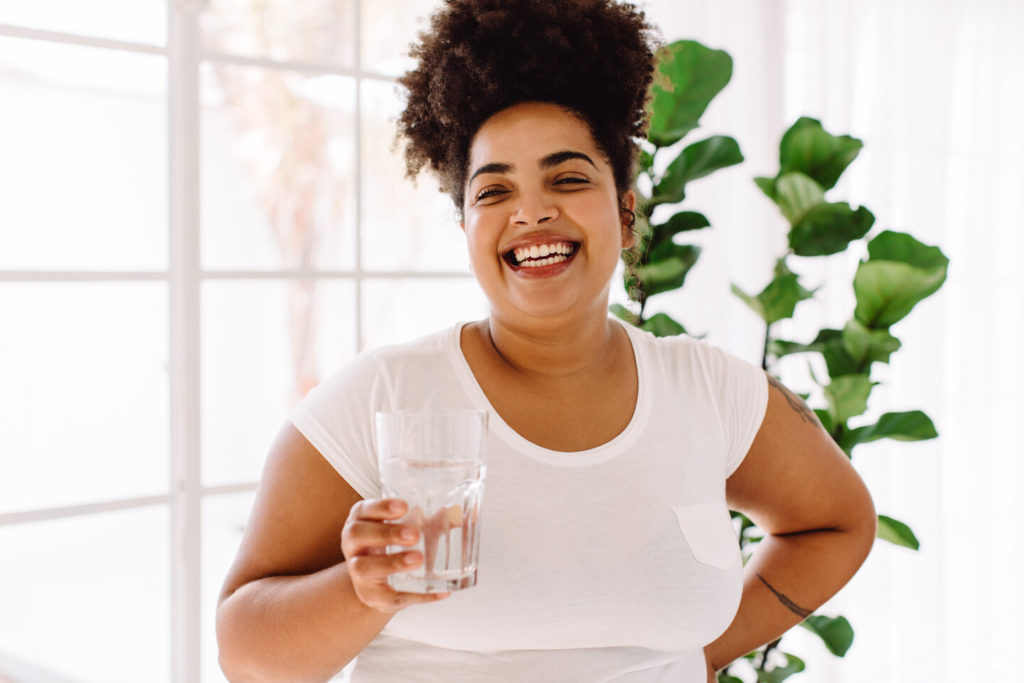 person holding glass of water that contains fluoride