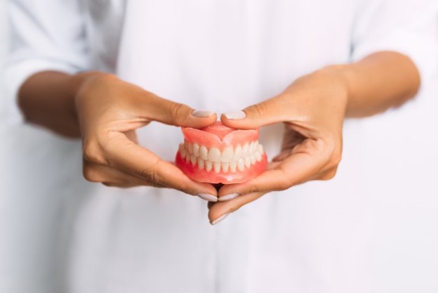 Dentist holding dentures.